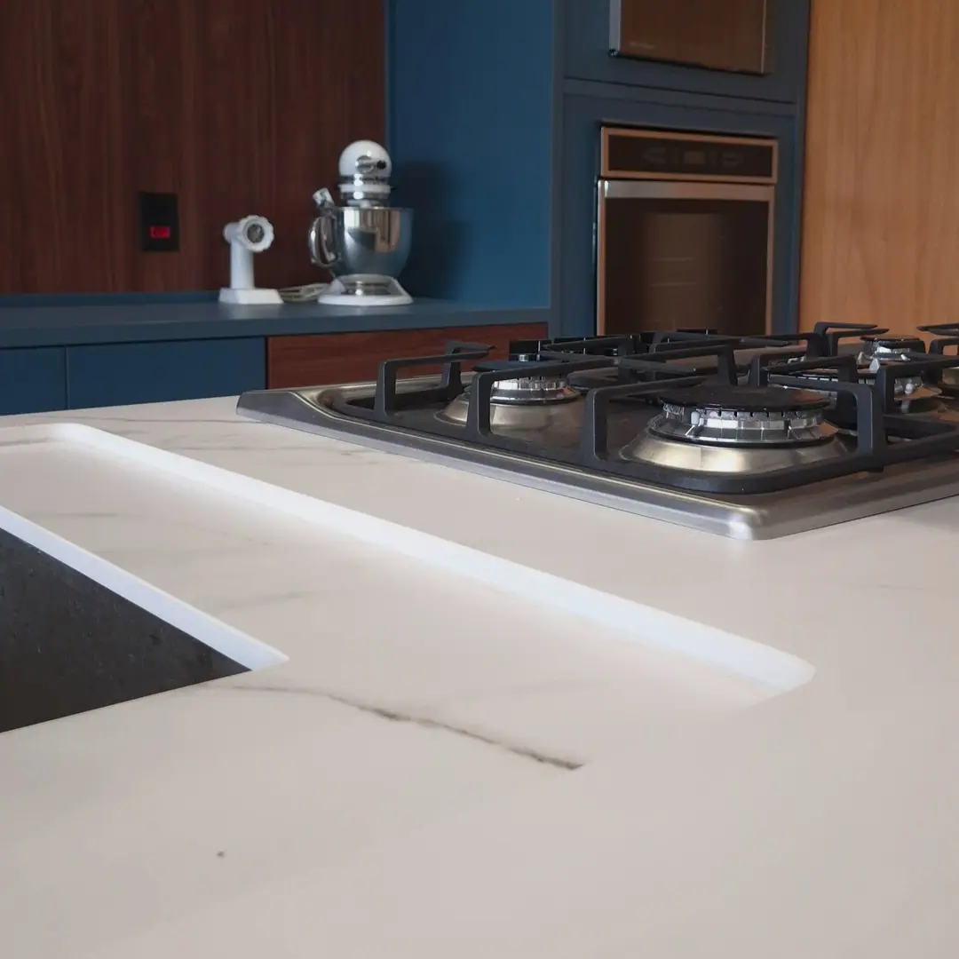 Detalhe da bancada em ultracompacto Calacata com cooktop embutido