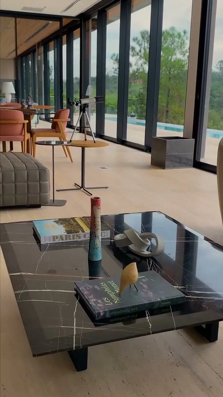 Mesa de centro em mármore Nero Marquina produzida pela G2M, em sala com fachada de vidro