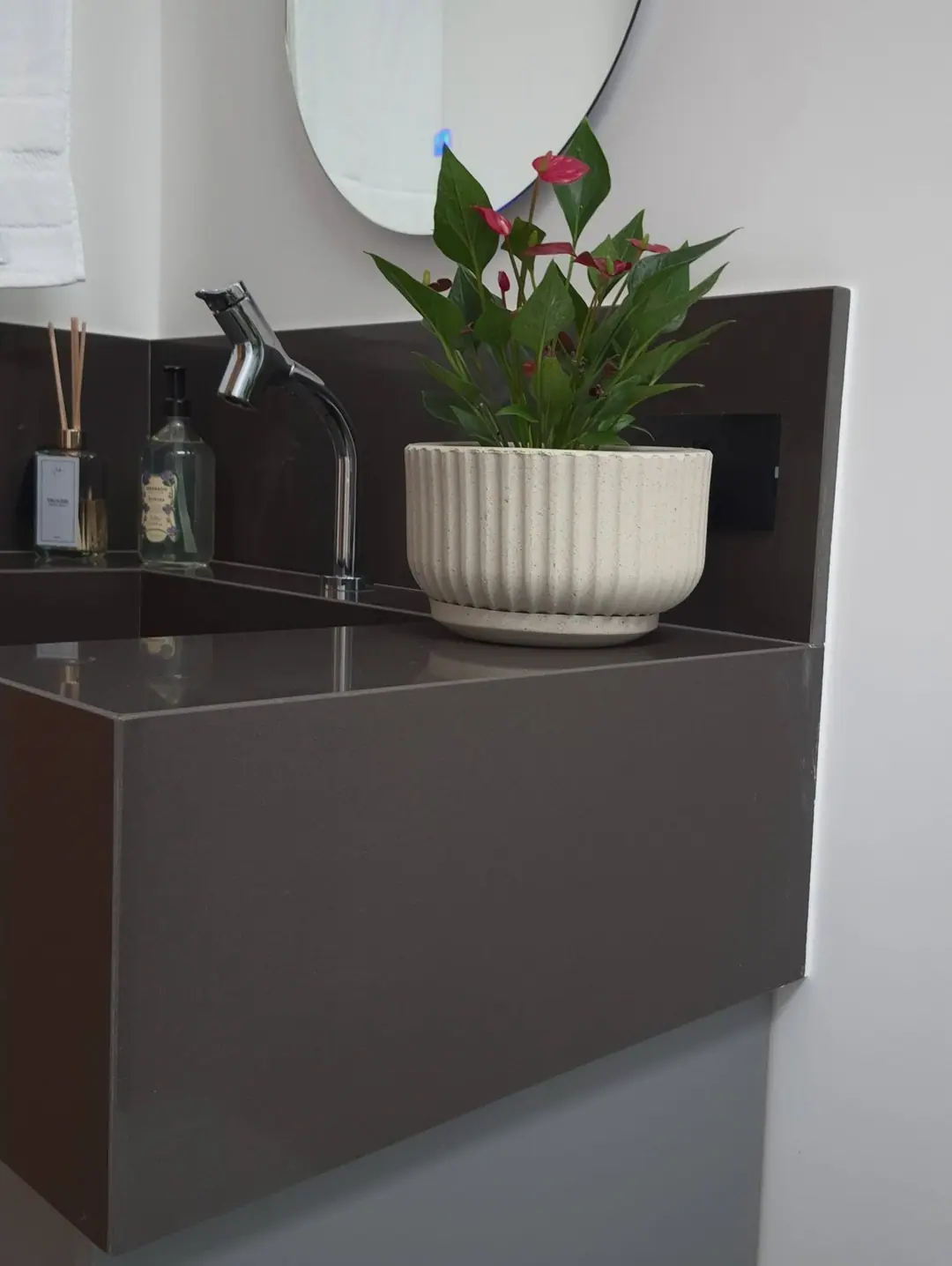 Detalhe da bancada em quartzo escuro com acabamento reto e preciso