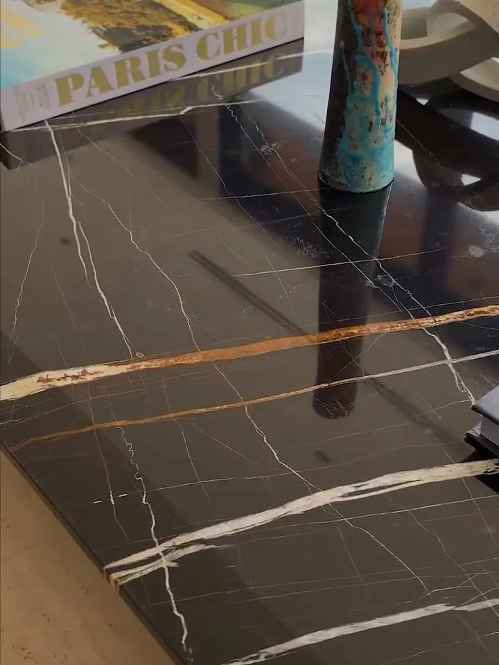 Close do tampo em mármore Nero Marquina, fundo preto com veios brancos marcantes